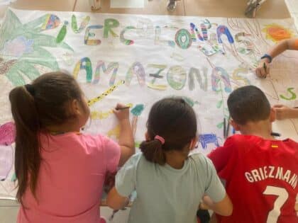 3 niños pintan el cartel de Divercolonias
